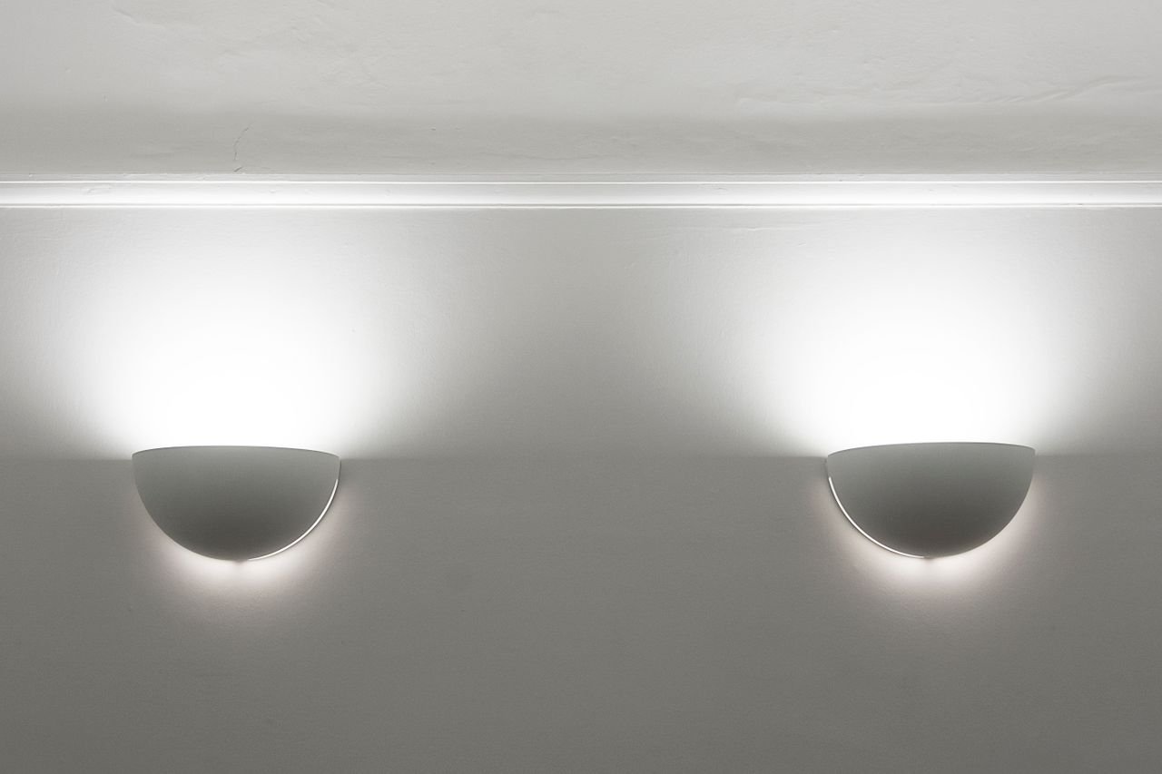 Elegant modern wall sconces casting ambient light on a plain white ceiling.
