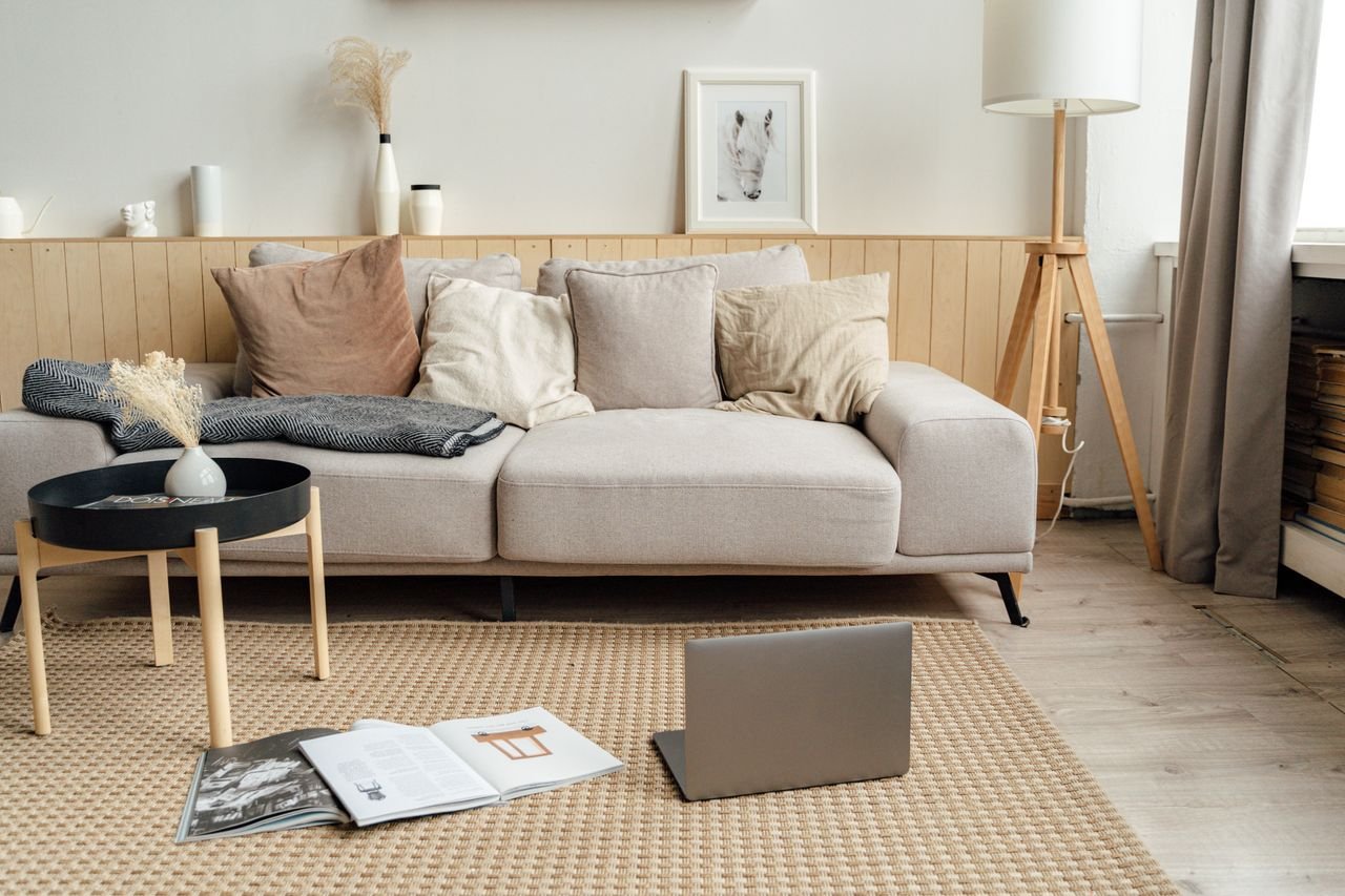 A contemporary living room featuring a sofa, laptop, and modern decor, ideal for remote work.